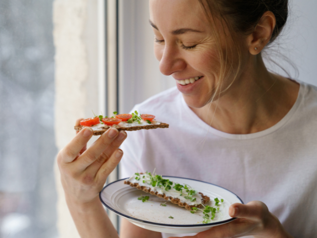 Vrouw eet crackers met groenten